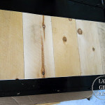 Lake Girl Paints fence board before